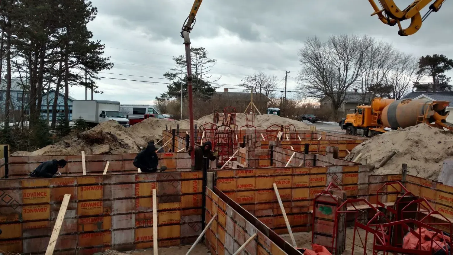 A construction site with a concrete pump in the background.