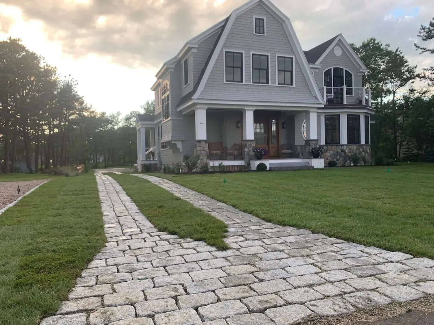 A large house with a brick driveway leading to it
