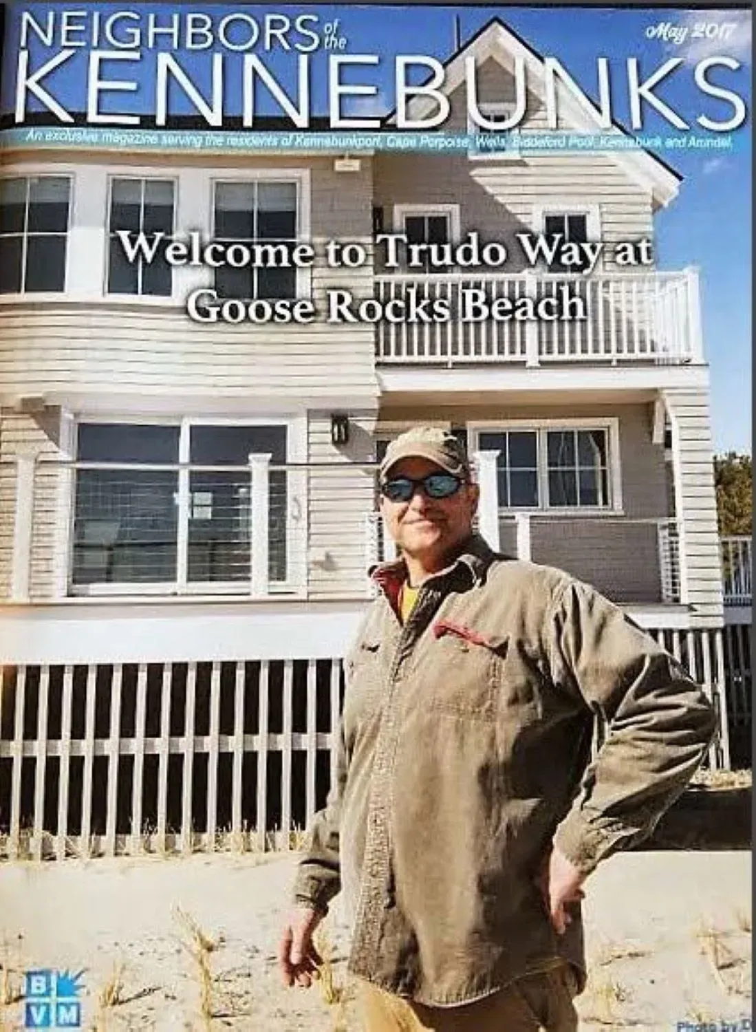 A man is standing in front of a house on the cover of a magazine