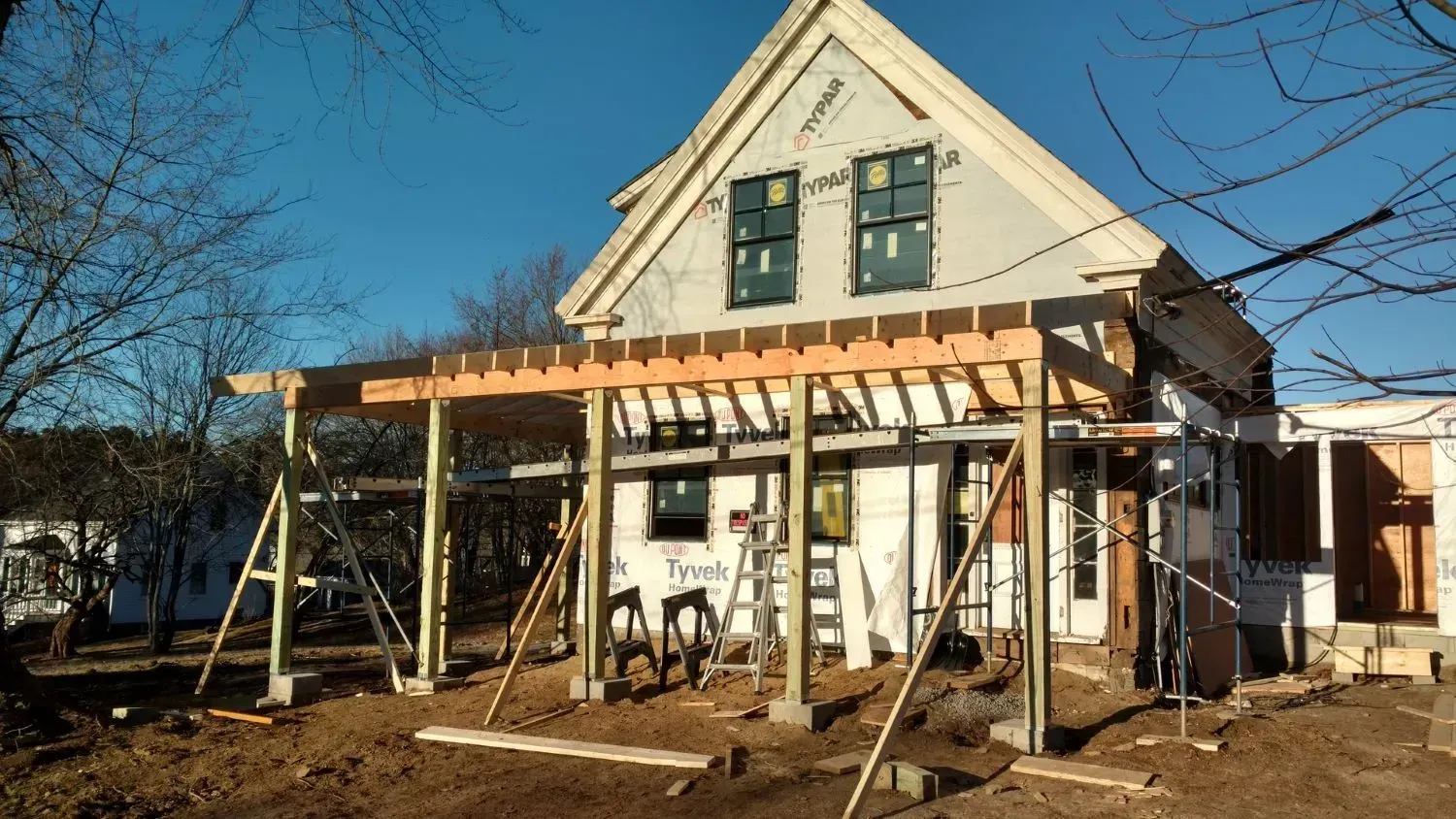 A house is being built with a porch and scaffolding.