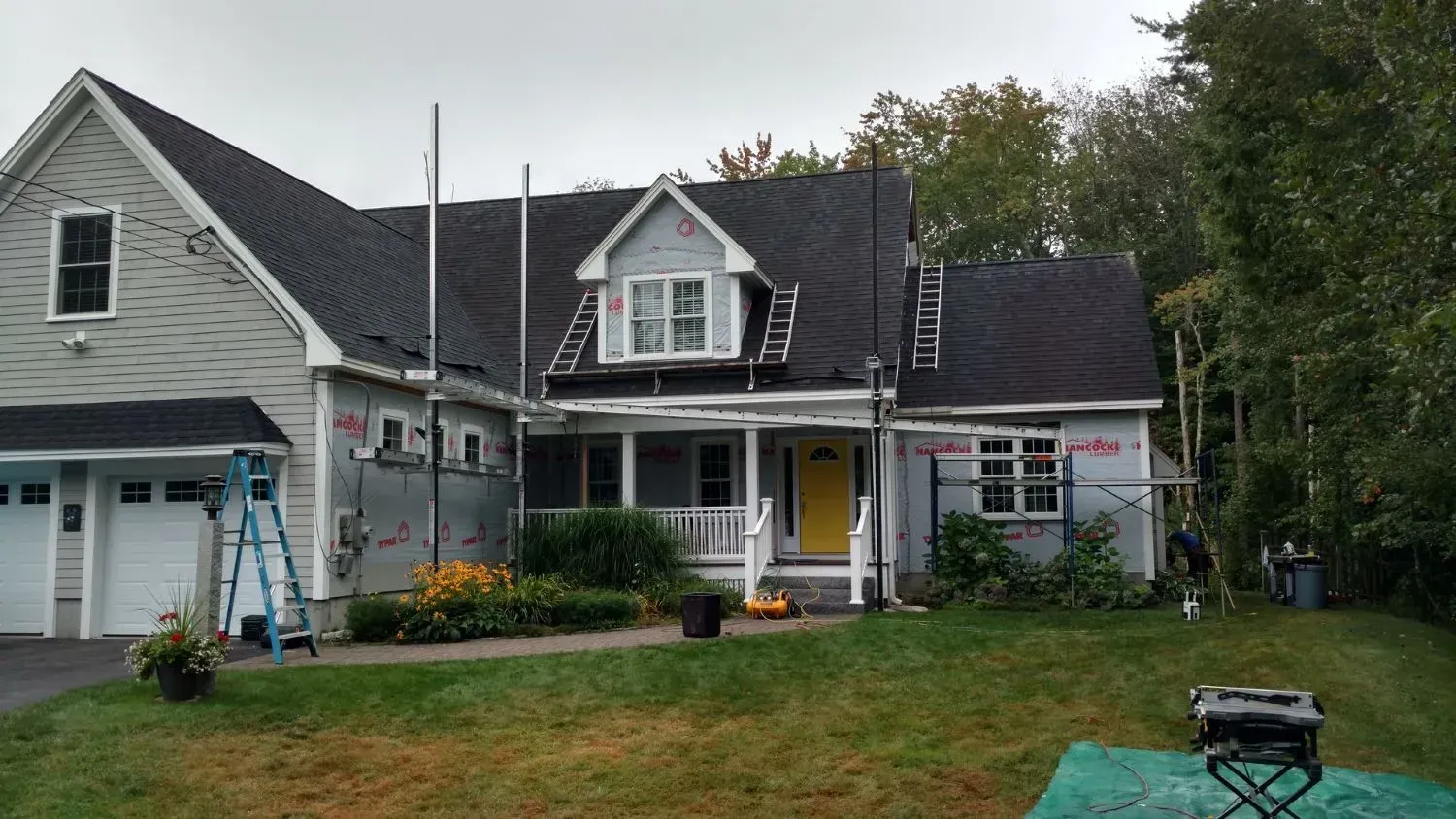 A house with a black roof is being remodeled.