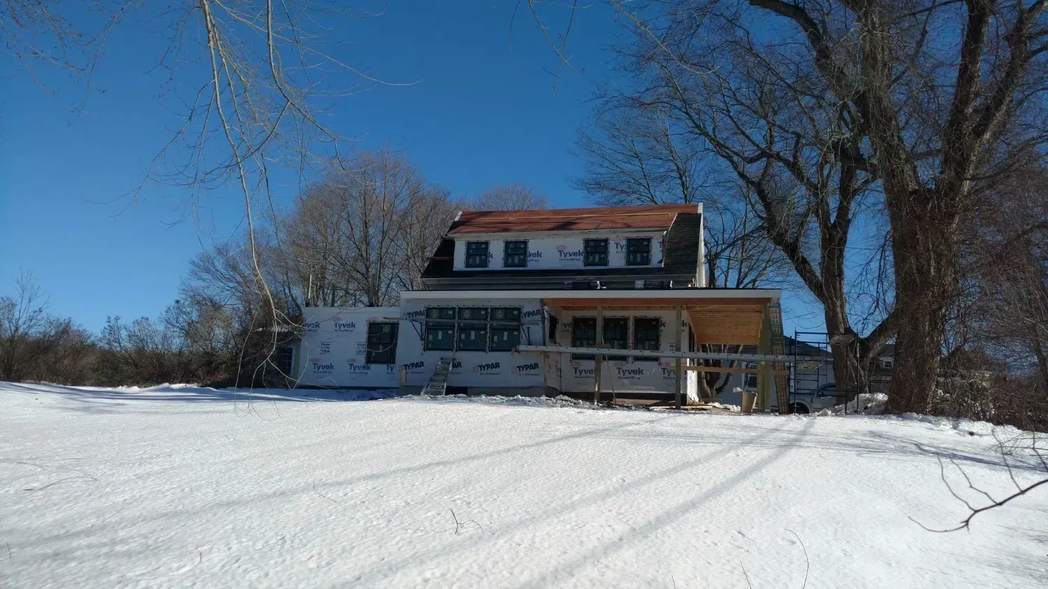 A house is being built in the middle of a snow covered field.