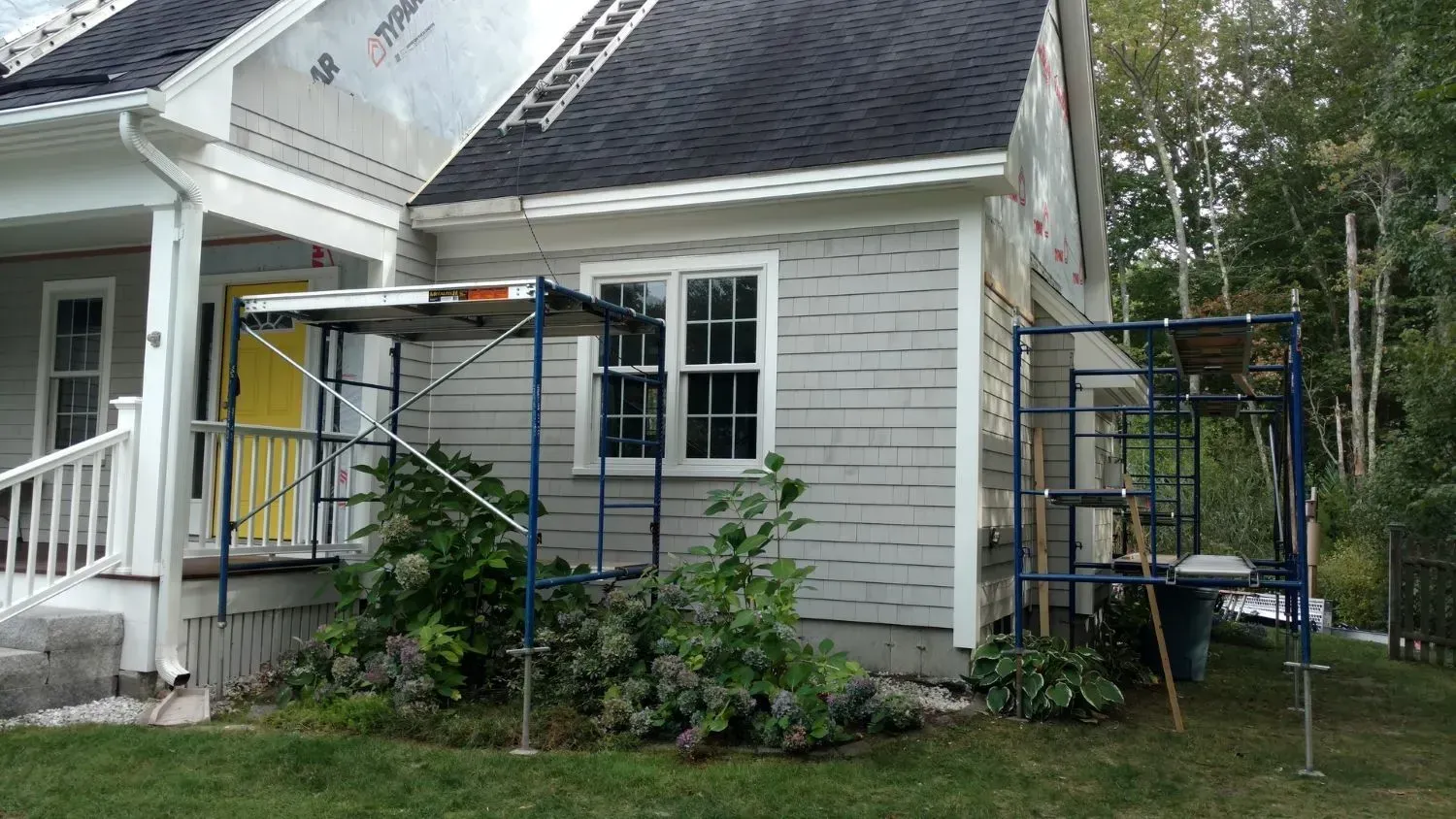 A house is being painted with scaffolding in front of it.