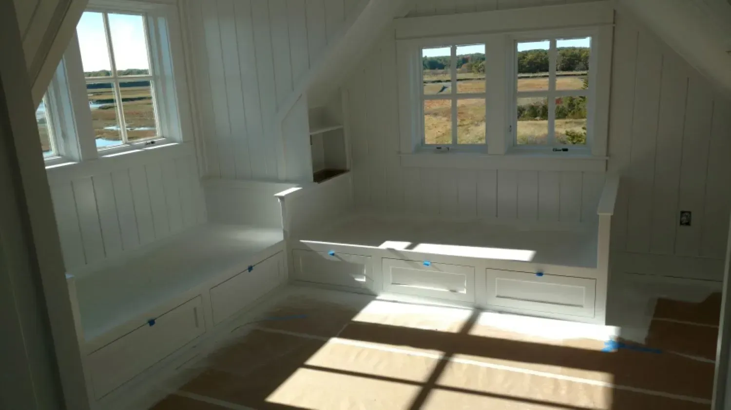 A room with a window and a bench in it