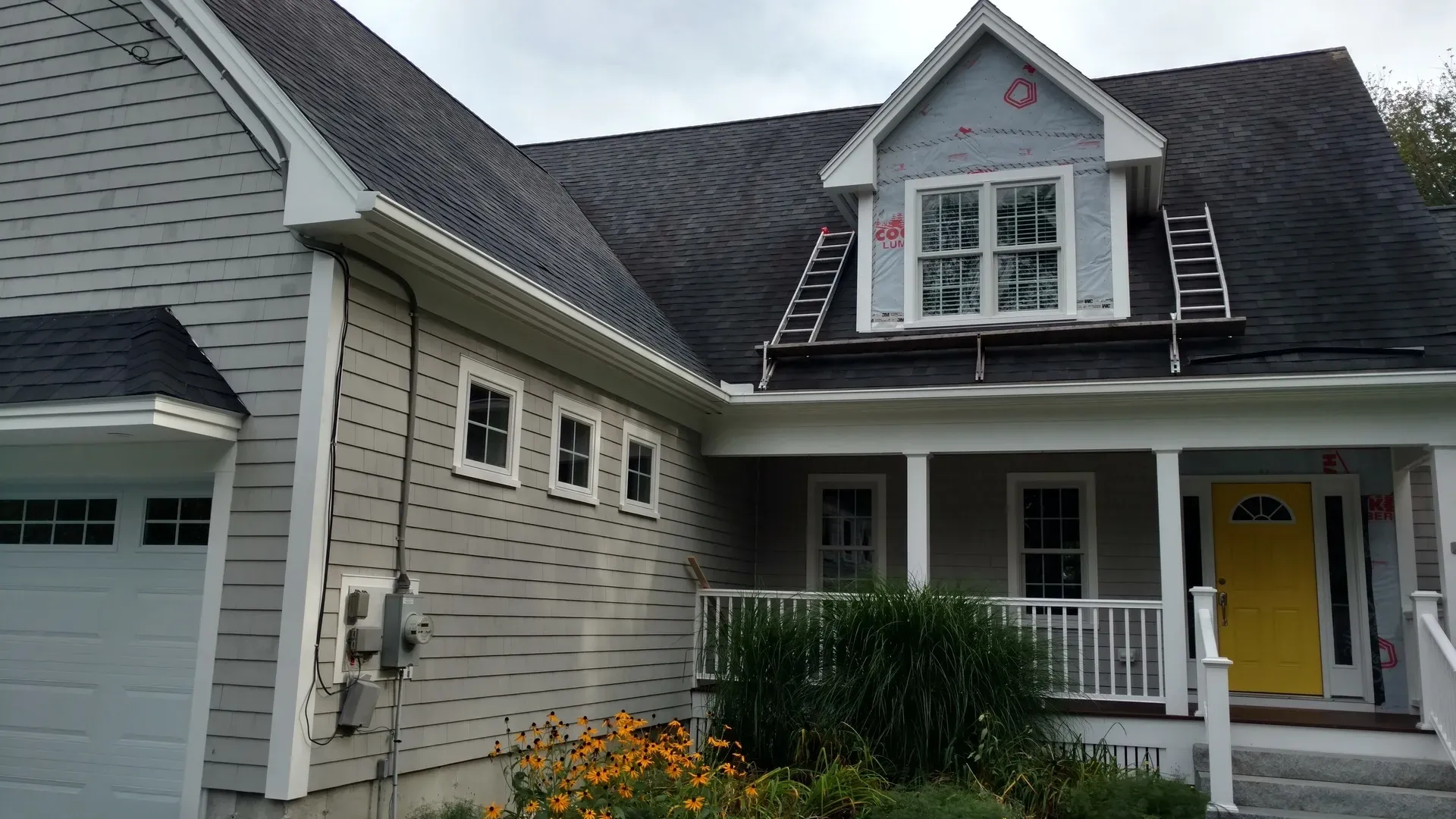 A house with a yellow door and a white garage door