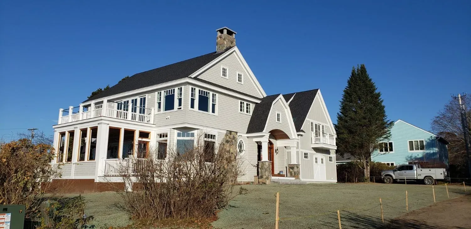 A large white house with a truck parked in front of it
