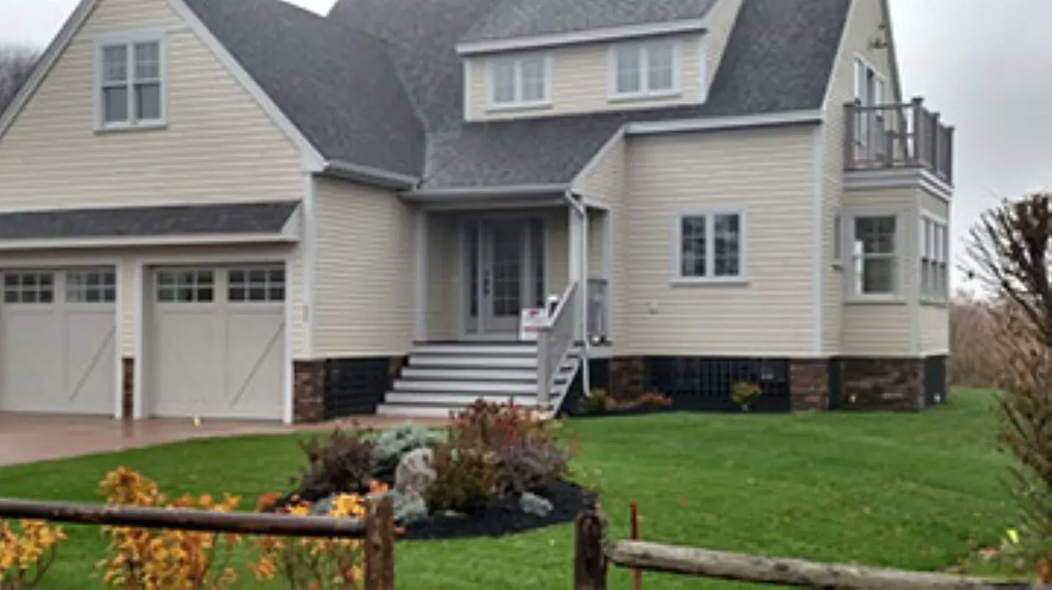 A large white house with a wooden fence in front of it.