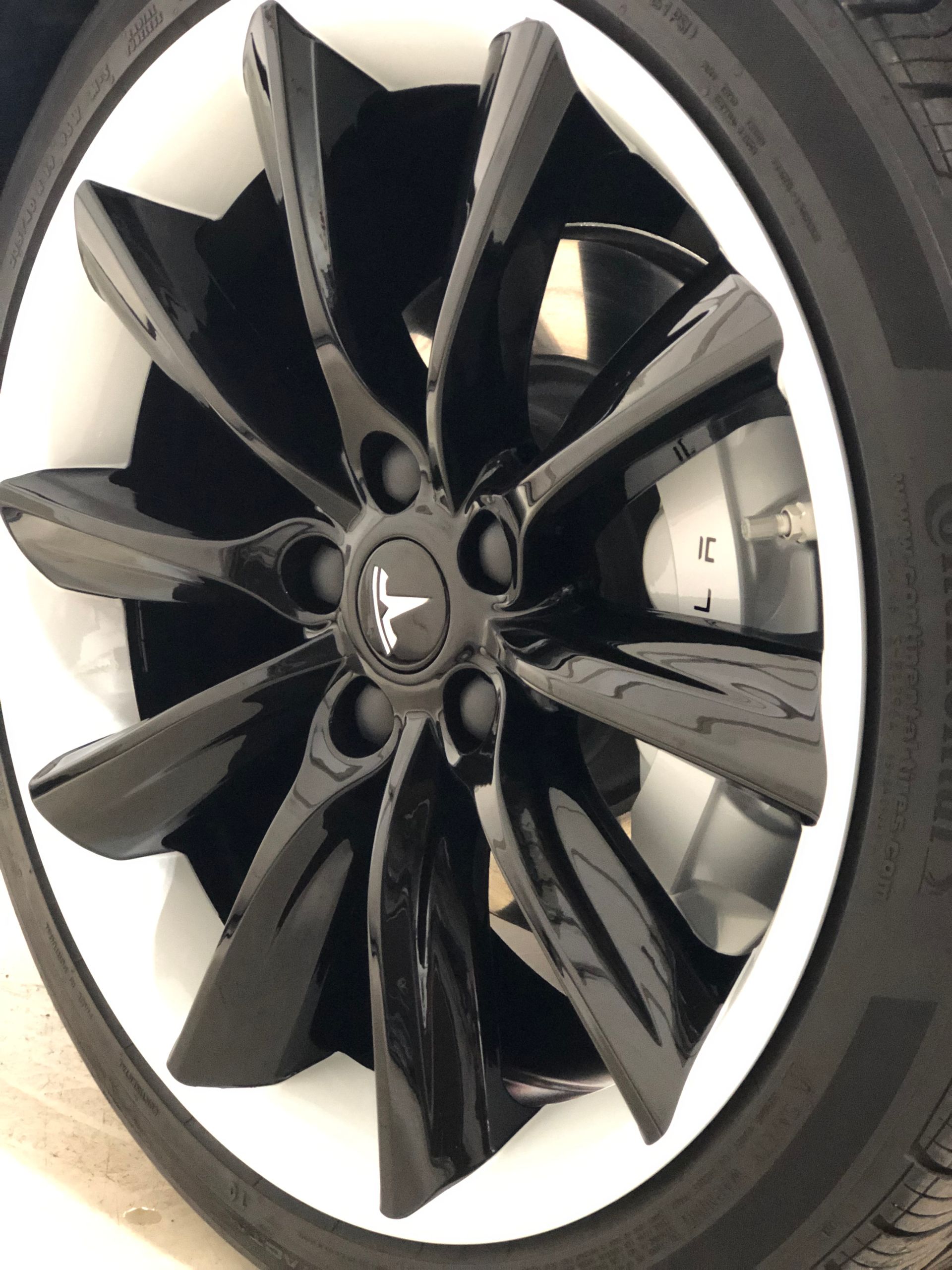 A close up of a tesla wheel with continental tire