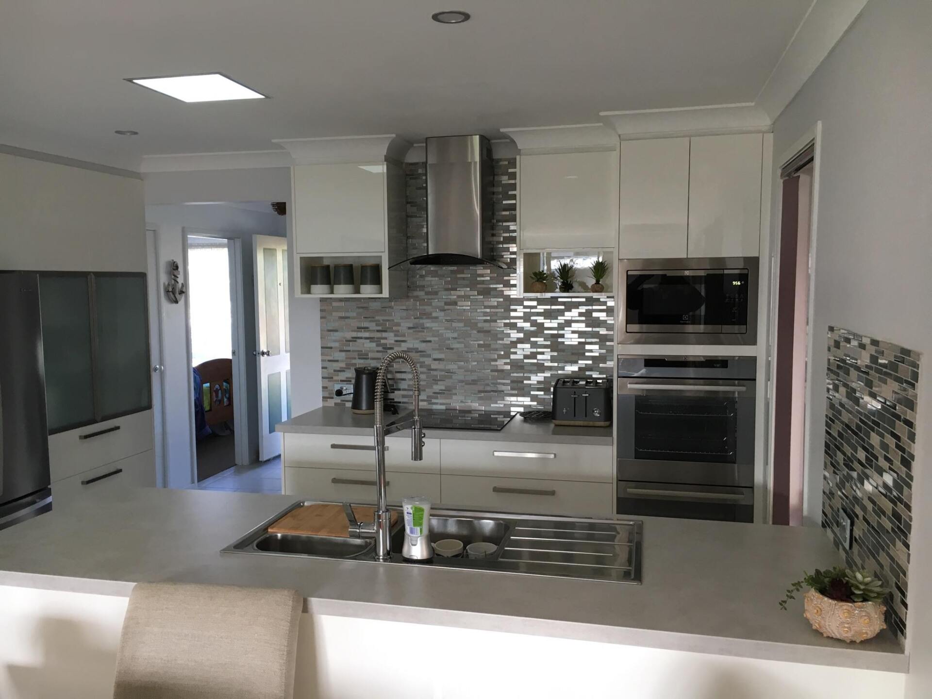 White Kitchen Cabinets With Silver Sink — Kitchen Designer in Erina, NSW