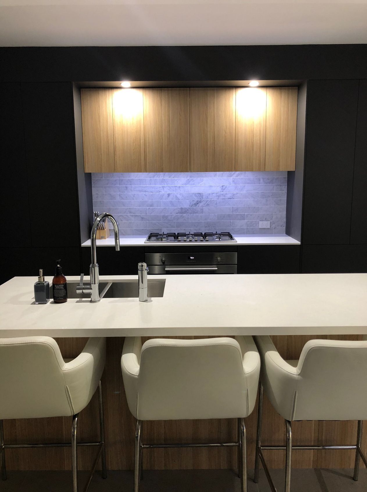 Black Modern Kitchen And White Bar Stools — Kitchen Designer in Morisset, NSW
