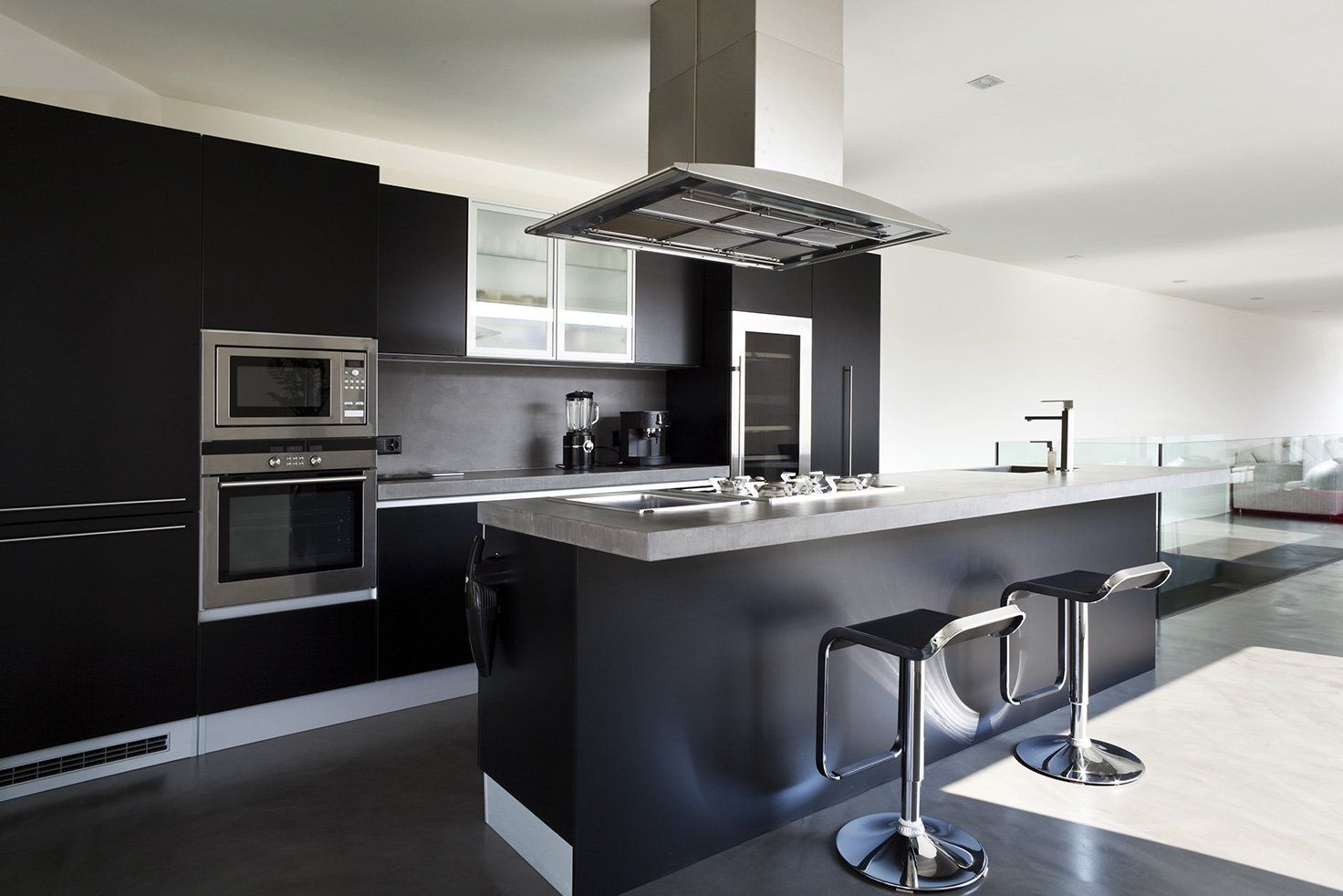 A Kitchen With Black Cabinets And Stainless Steel Appliances — Hats Off Kitchens in Sydney Northern Beaches, NSW