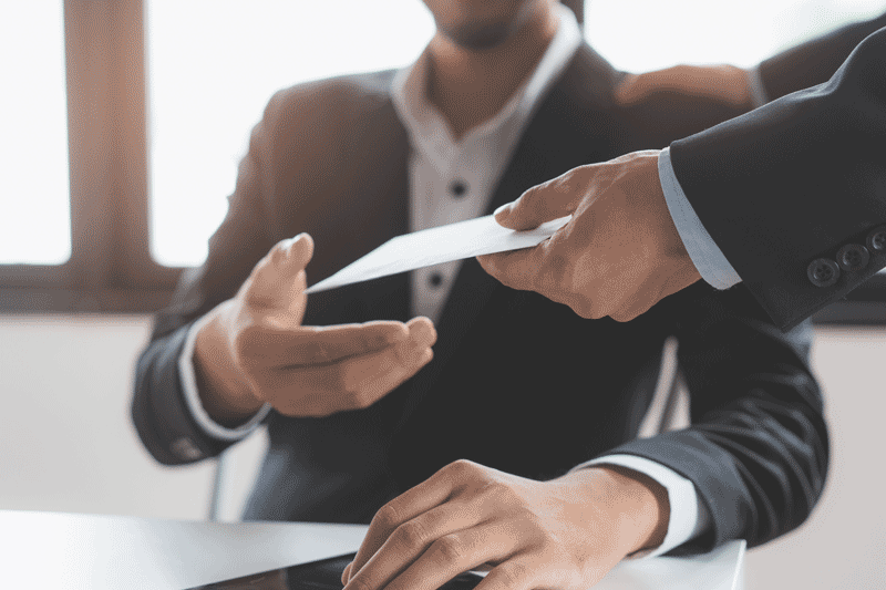 man in suit being handed paycheck