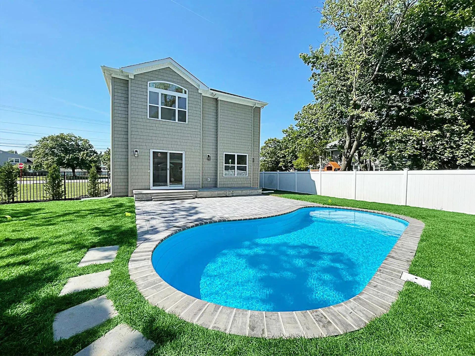 A large house with a large swimming pool in front of it.