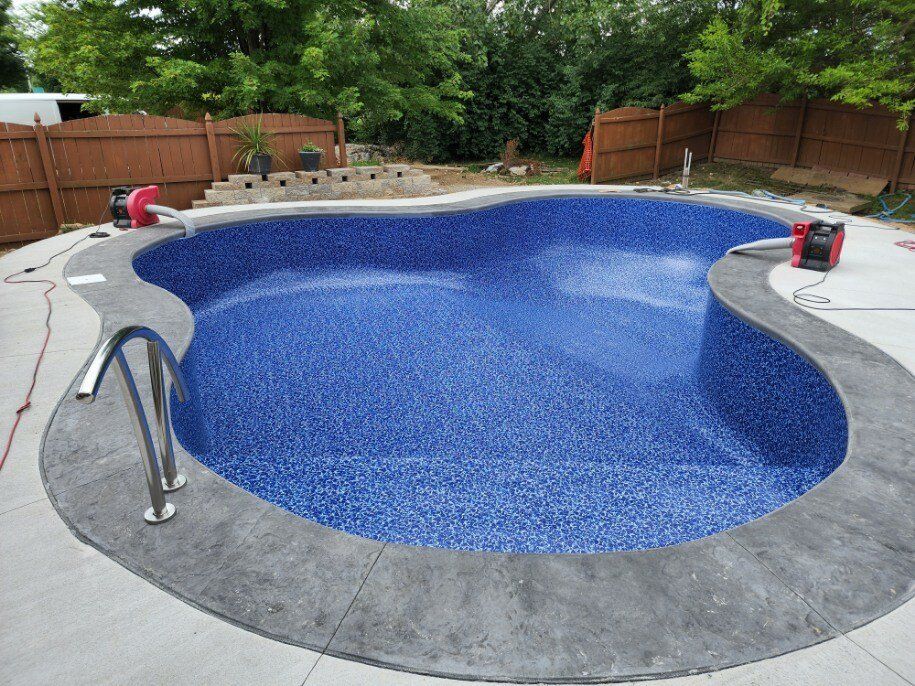A large blue swimming pool is being built in a backyard.