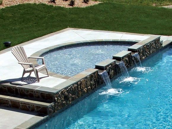 A chair sits on the edge of a swimming pool