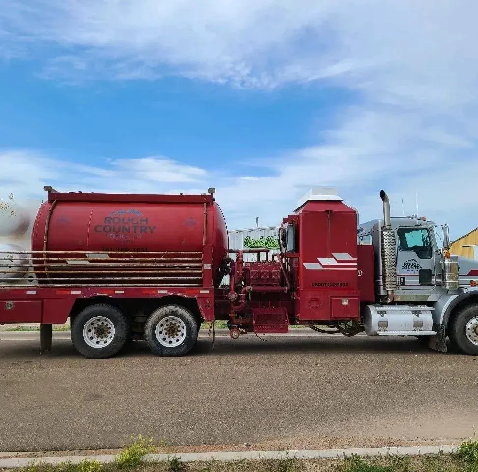 A red tanker truck is parked on the side of the road