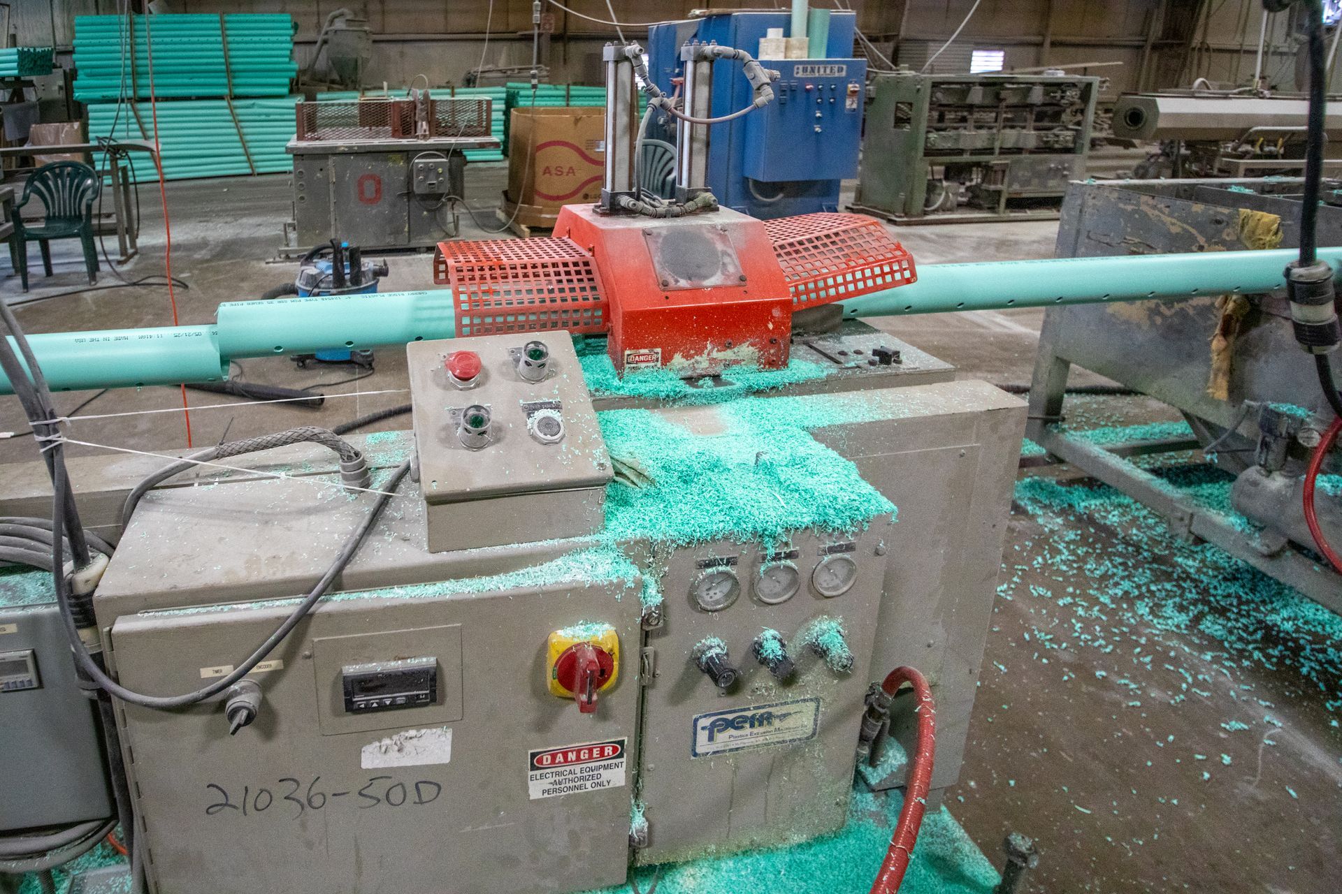 Exterior of Tolloff Pipe business; red building, white sign, gravel lot, cloudy sky.