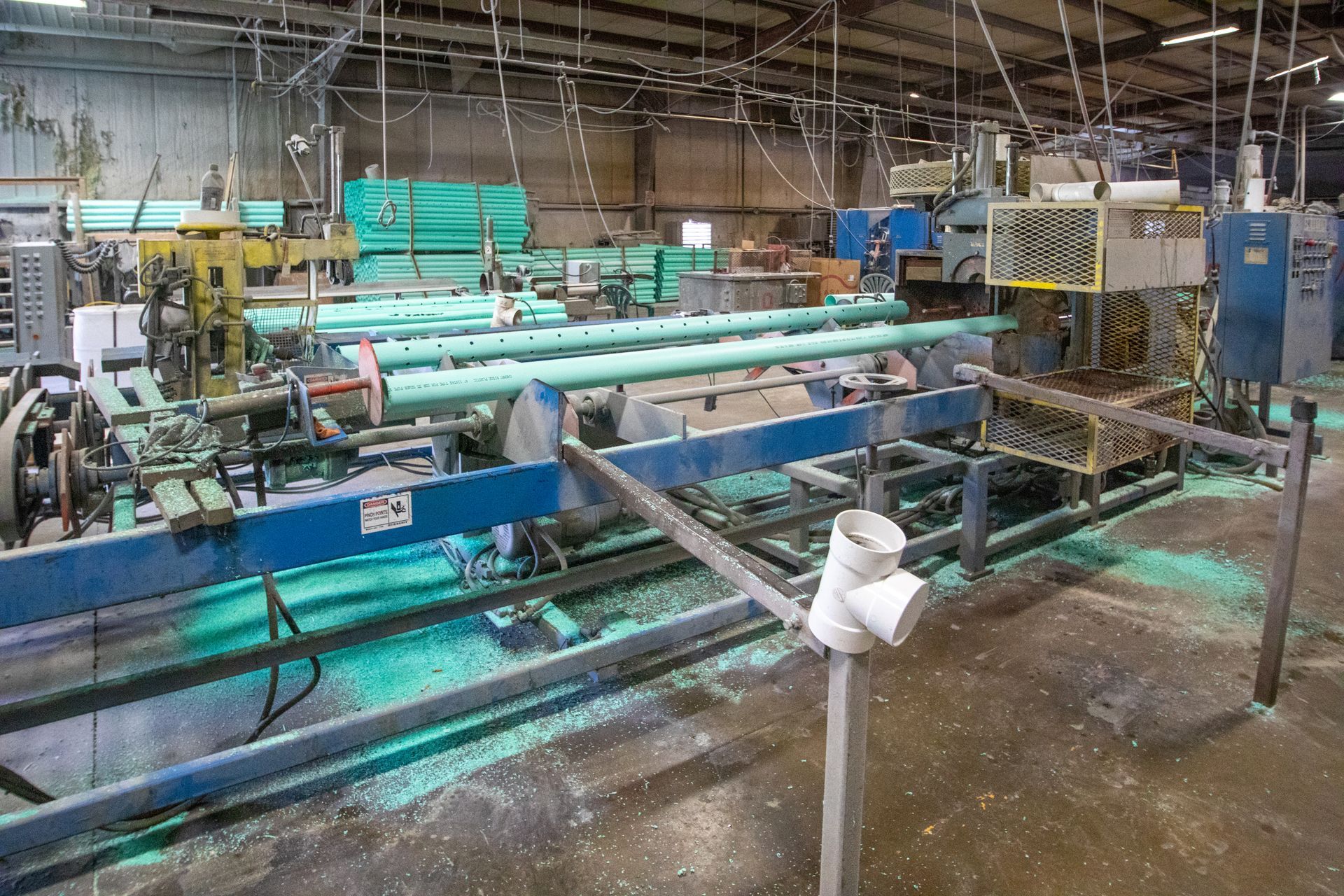 Exterior of Tolloff Pipe business; red building, white sign, gravel lot, cloudy sky.