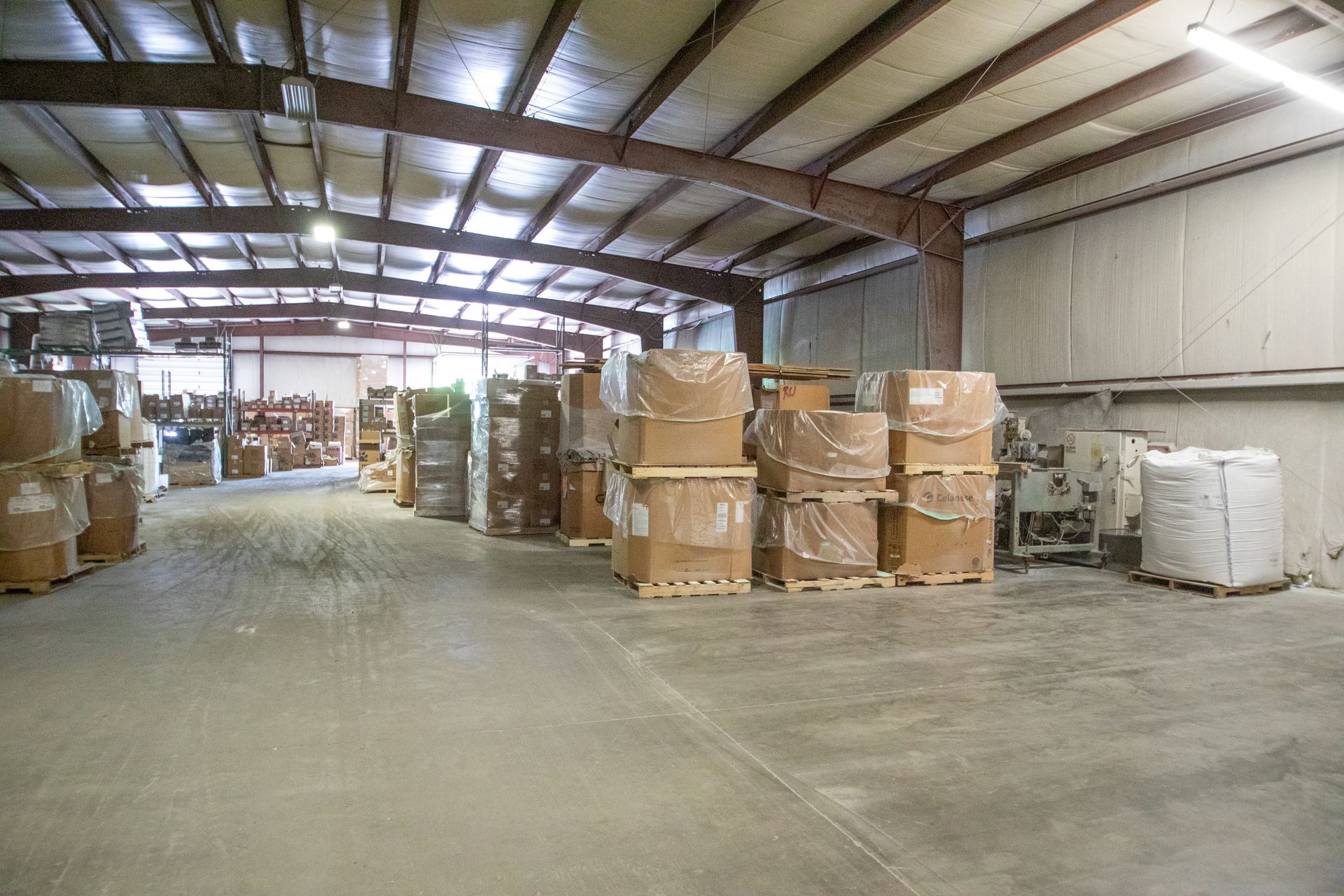 Warehouse interior with stacks of packaged goods on pallets.