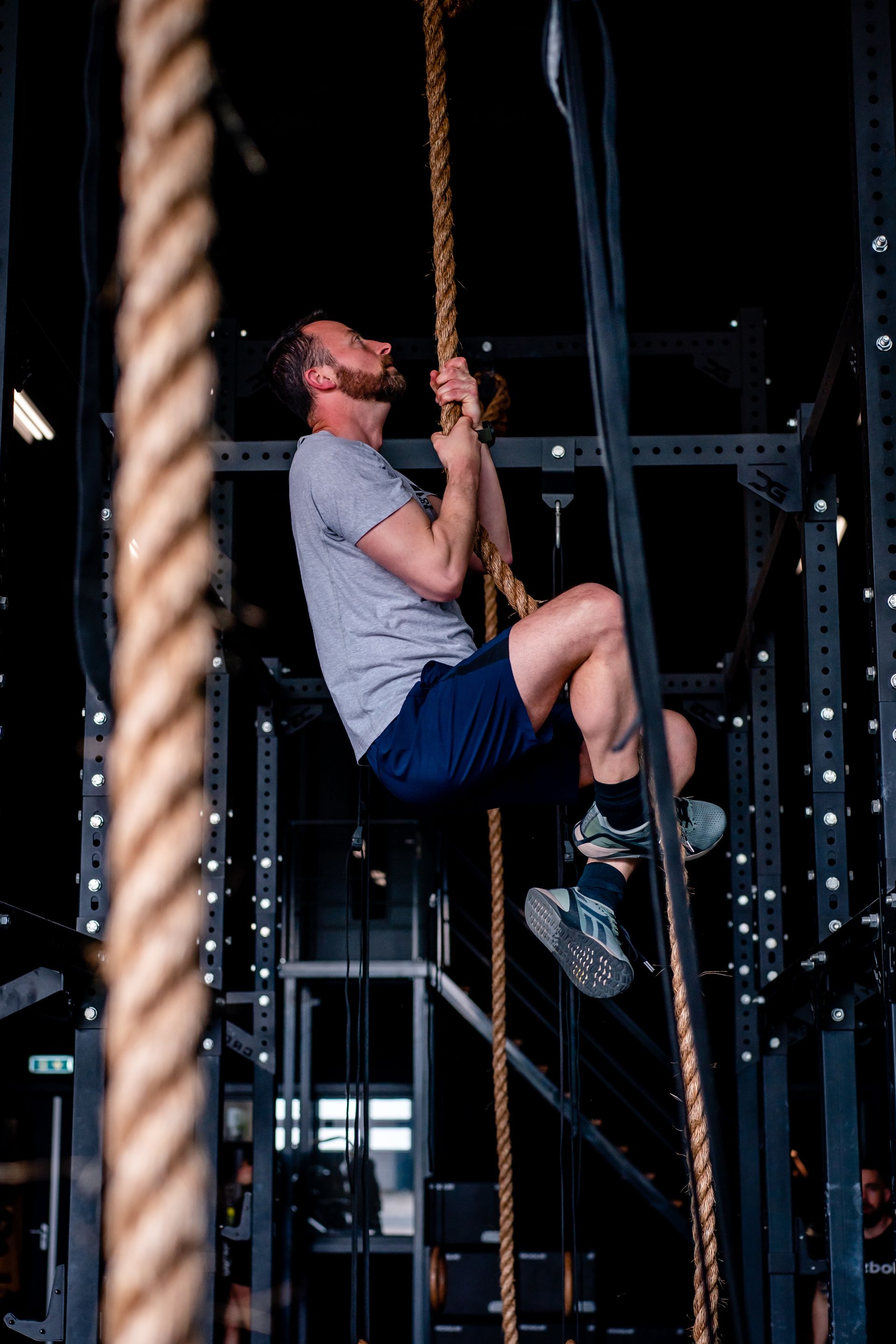 Een man klimt in een touw in een sportschool.