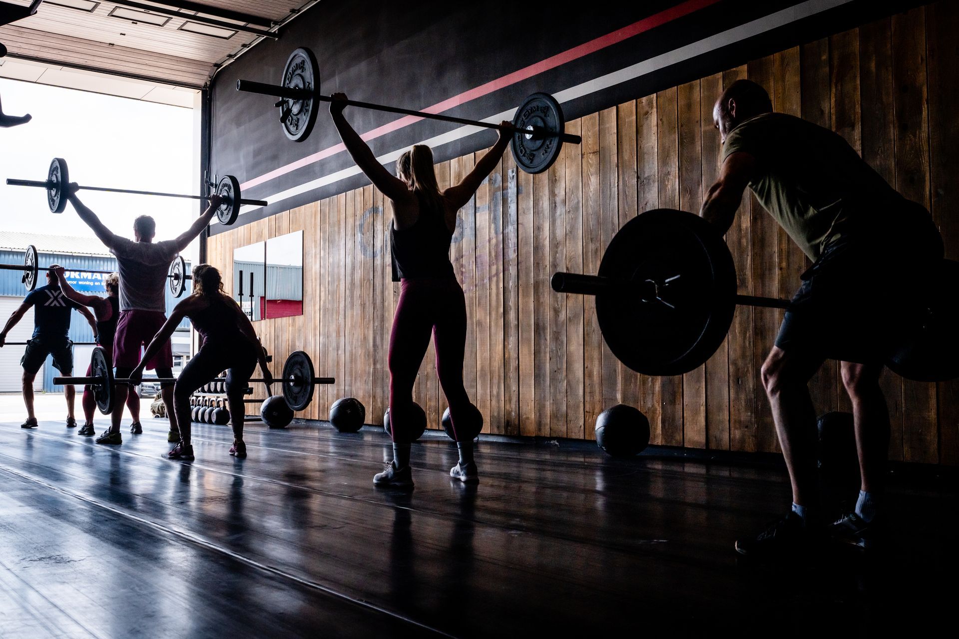 Een groep mensen is bezig met het heffen van gewichten in een sportschool.