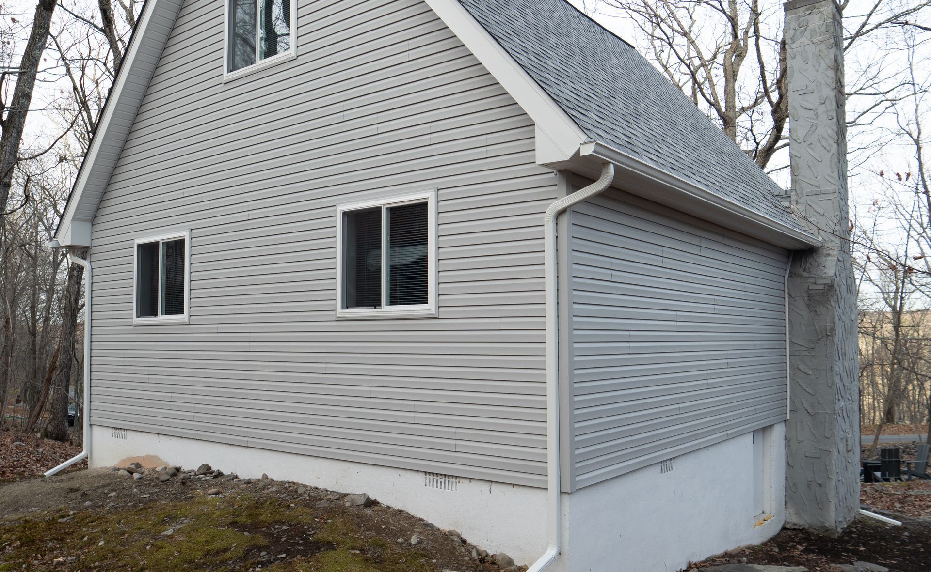 A white house with a chimney on the side of it
