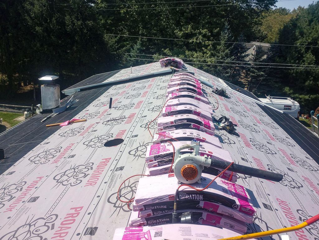 A roof with a lot of pink and gray materials on it