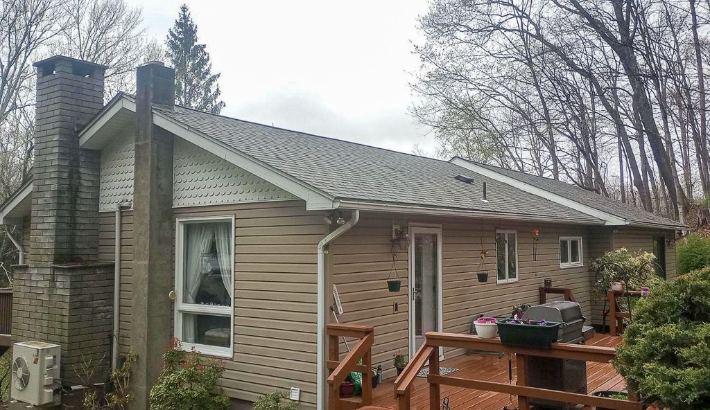 A house with a gray roof and a wooden deck.