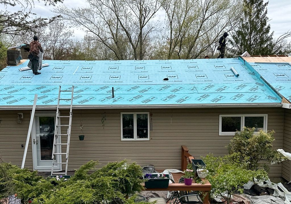 Two men are working on the roof of a house.
