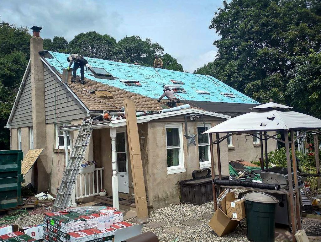 A house with a blue roof is being remodeled.