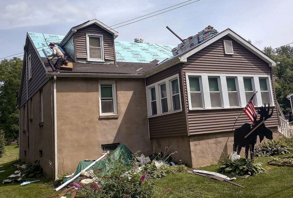 A man is working on the roof of a house