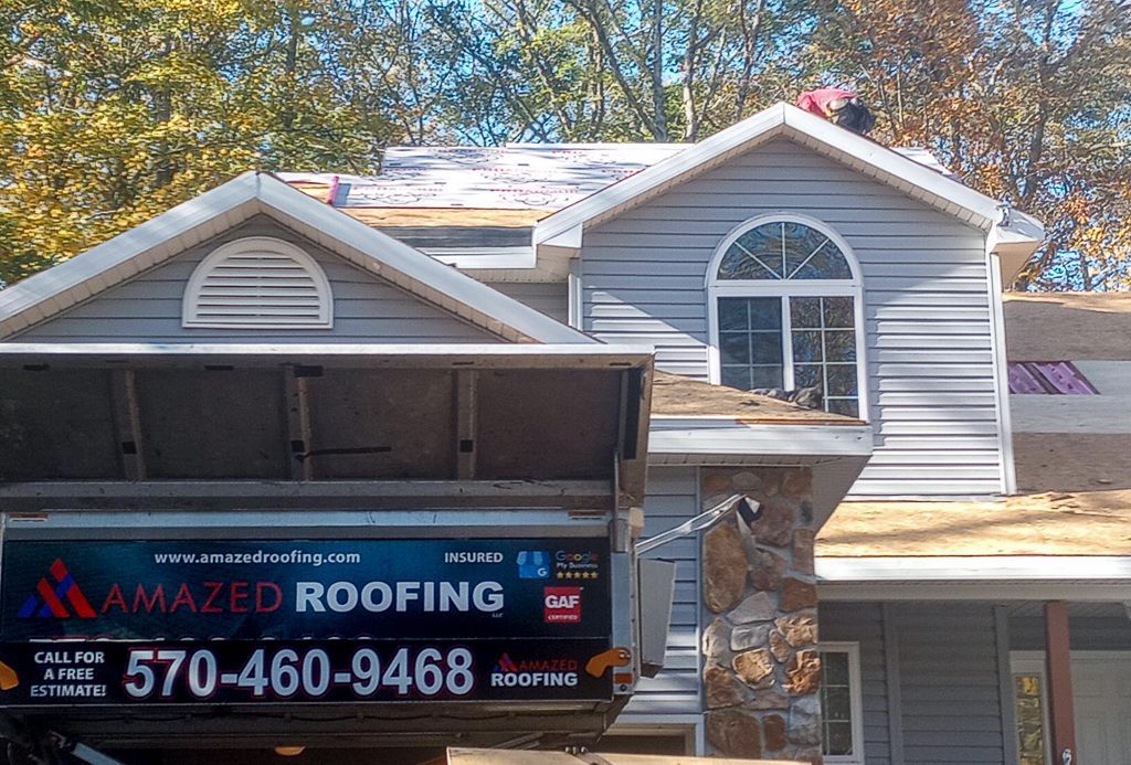 A house with a sign that says amazed roofing on it