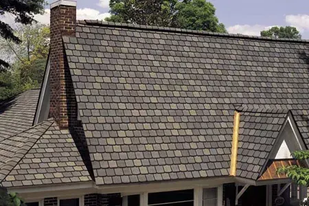 A house with a gray roof and a brick chimney