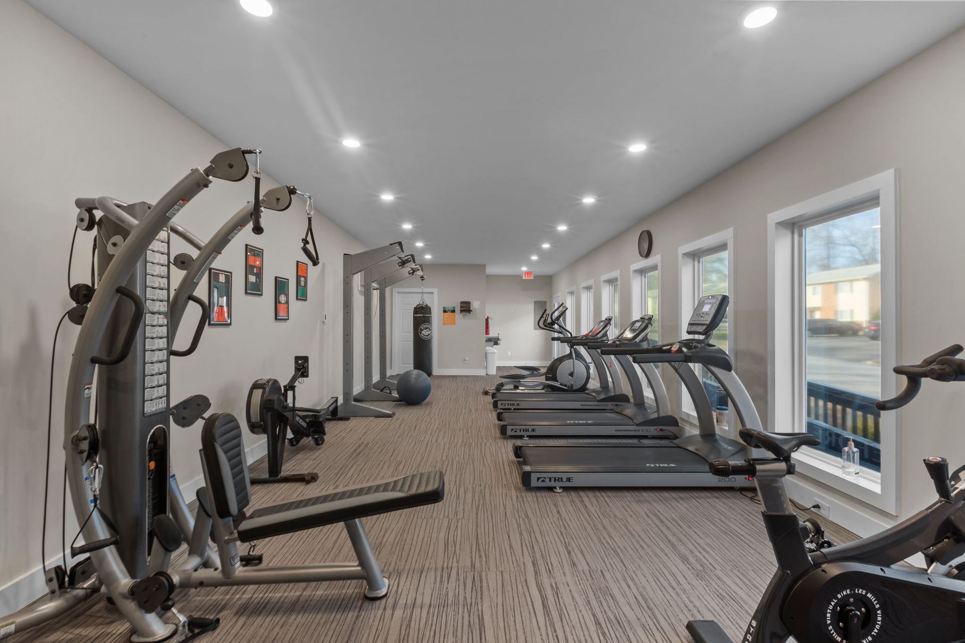 A large gym with a lot of treadmills and exercise bikes.