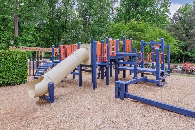 A playground with a slide , stairs , and a balance beam.