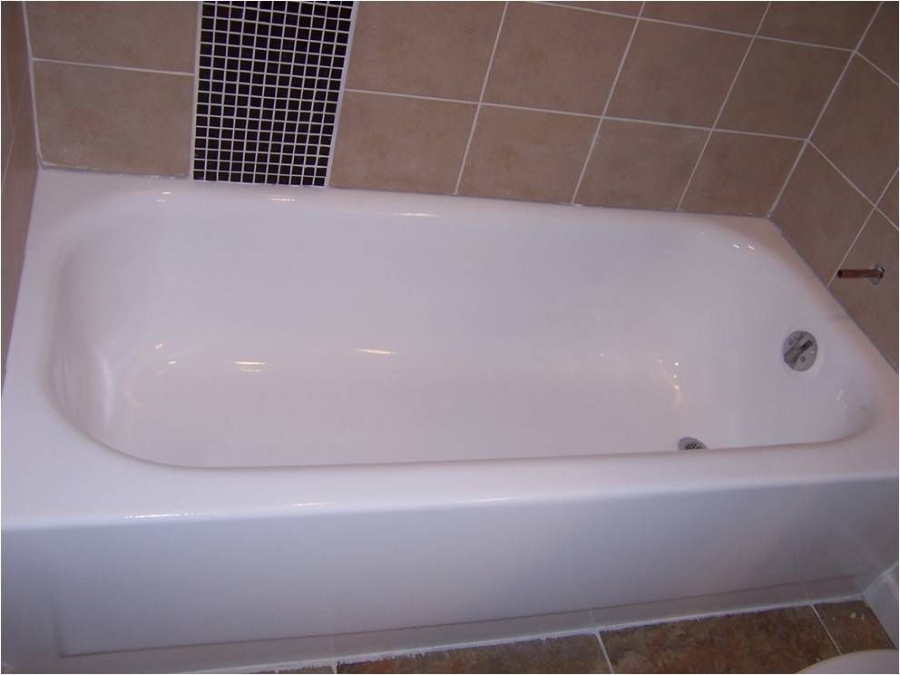 A white bathtub in a bathroom next to a tiled wall