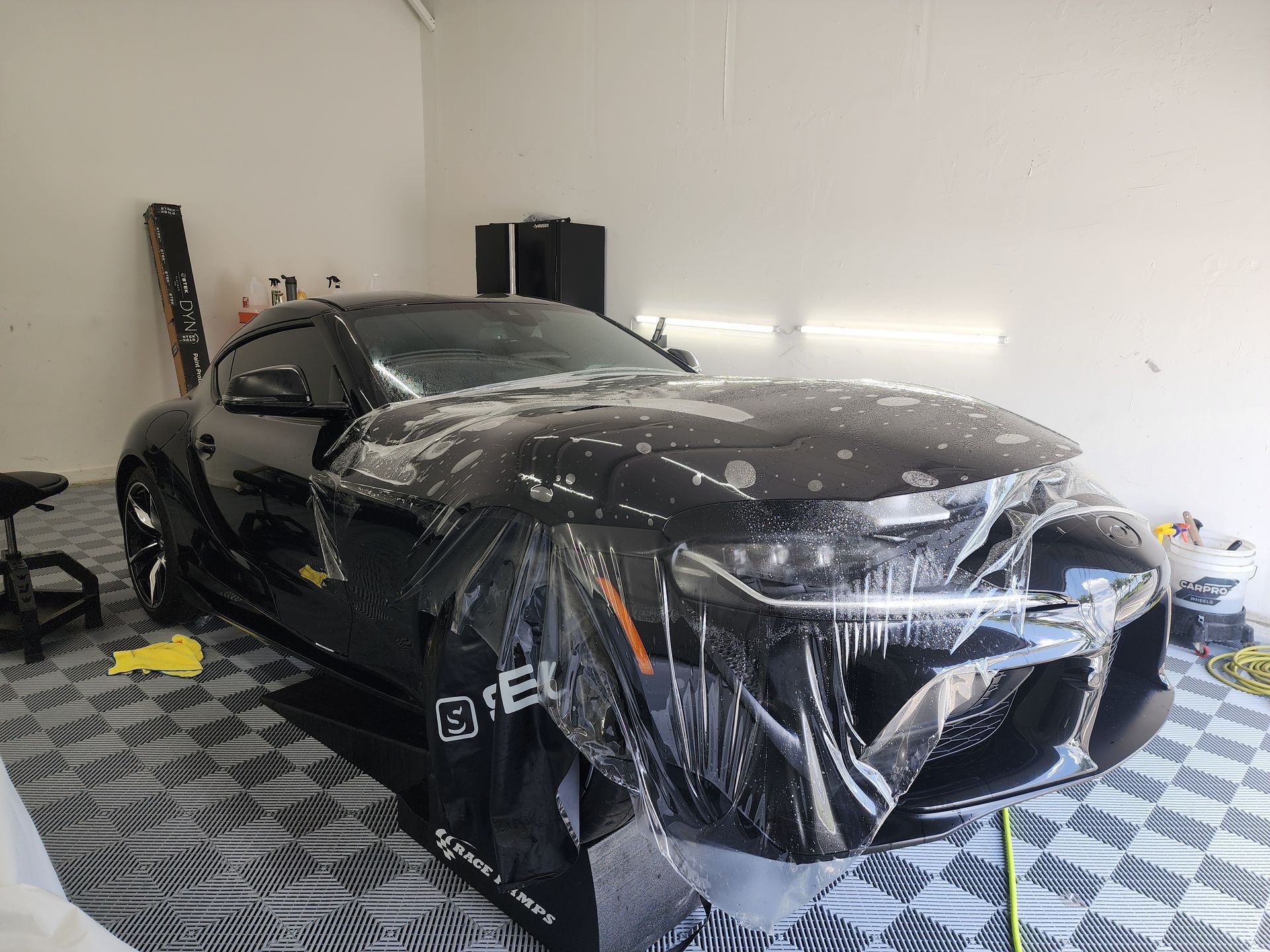 Red Honda Civic Type R with gold wheels parked in a garage with a tiled floor.
