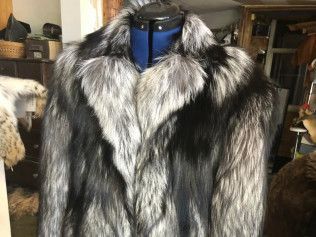 A black and silver fur coat is on a mannequin.