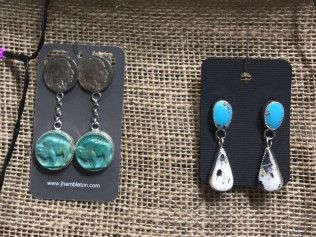 Two pairs of earrings are sitting on a table.