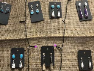 A bunch of earrings are hanging on a wall.