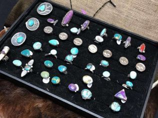 A black tray filled with a variety of rings.