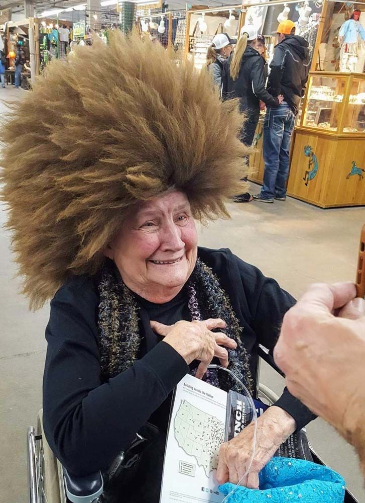 A woman in a wheelchair wearing a large wig