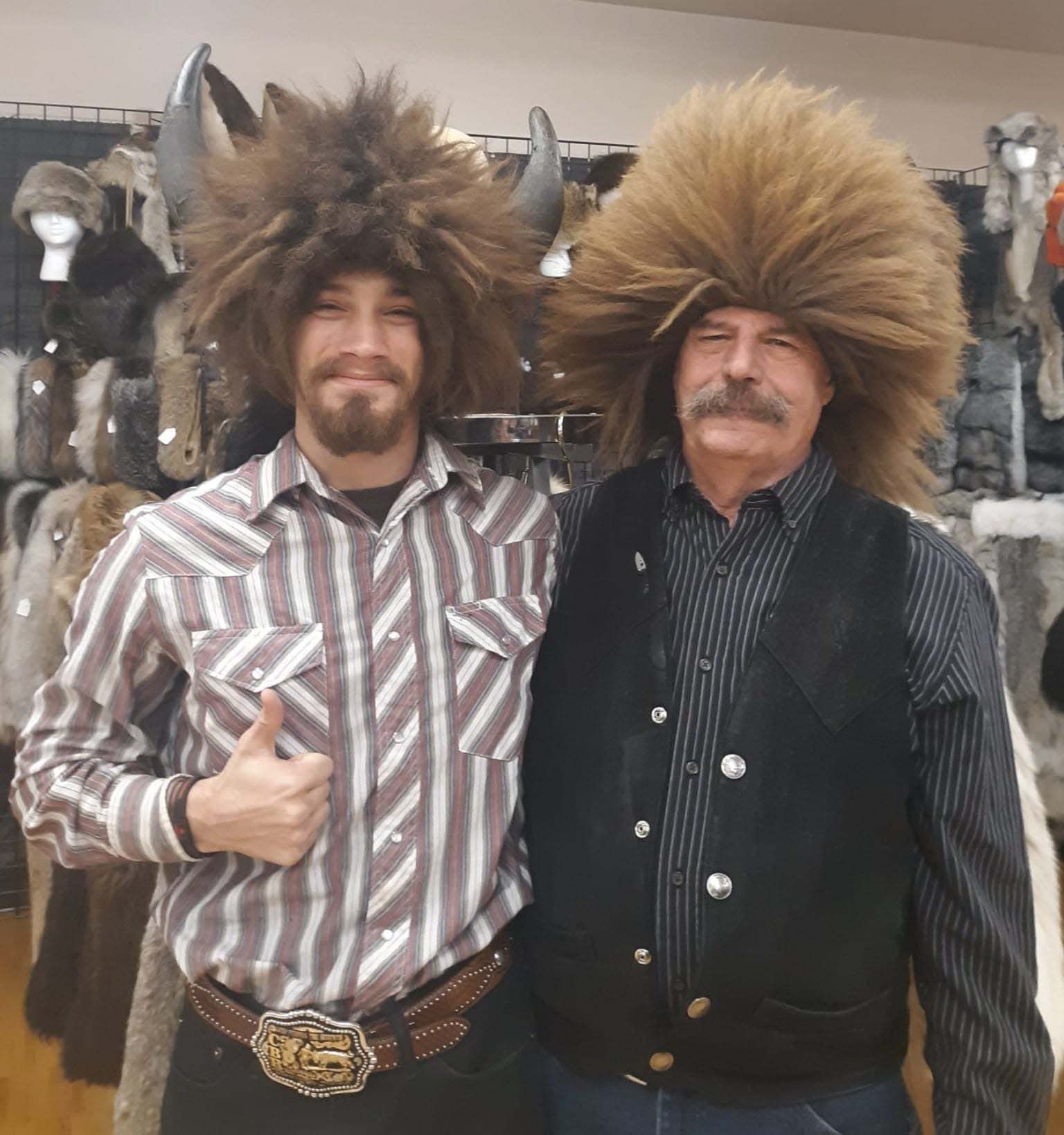 Two men posing for a picture with one wearing a cowboy hat