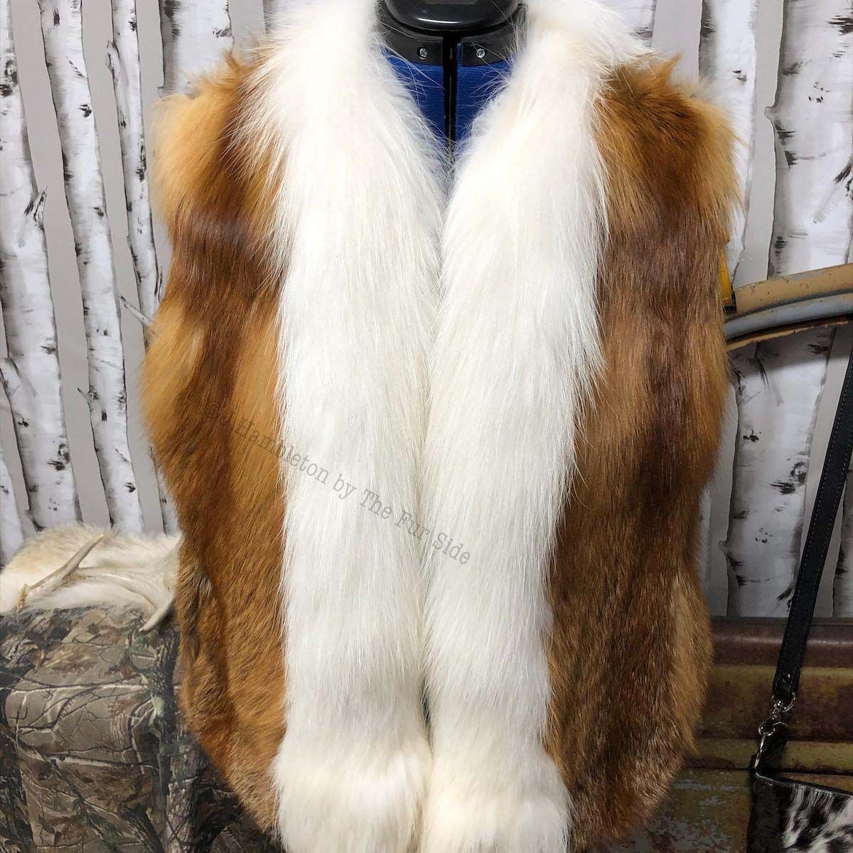 A brown and white fur vest is on a mannequin.