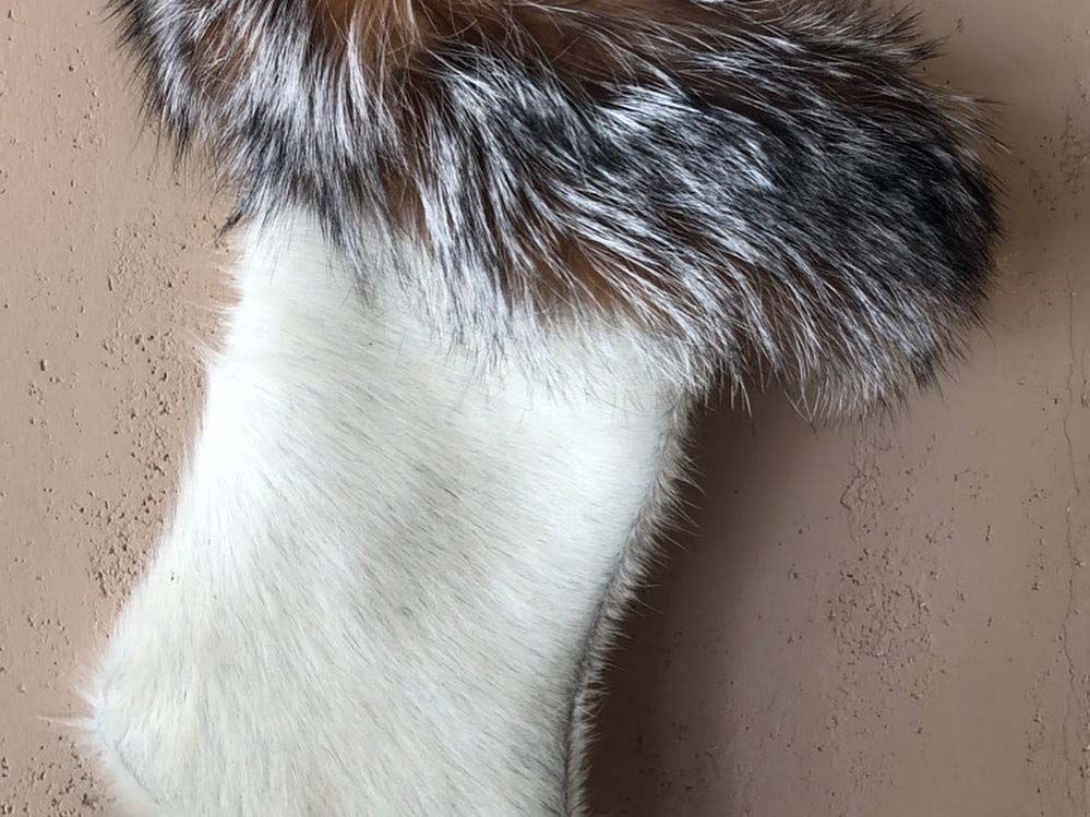 A close up of a furry christmas stocking on a table.