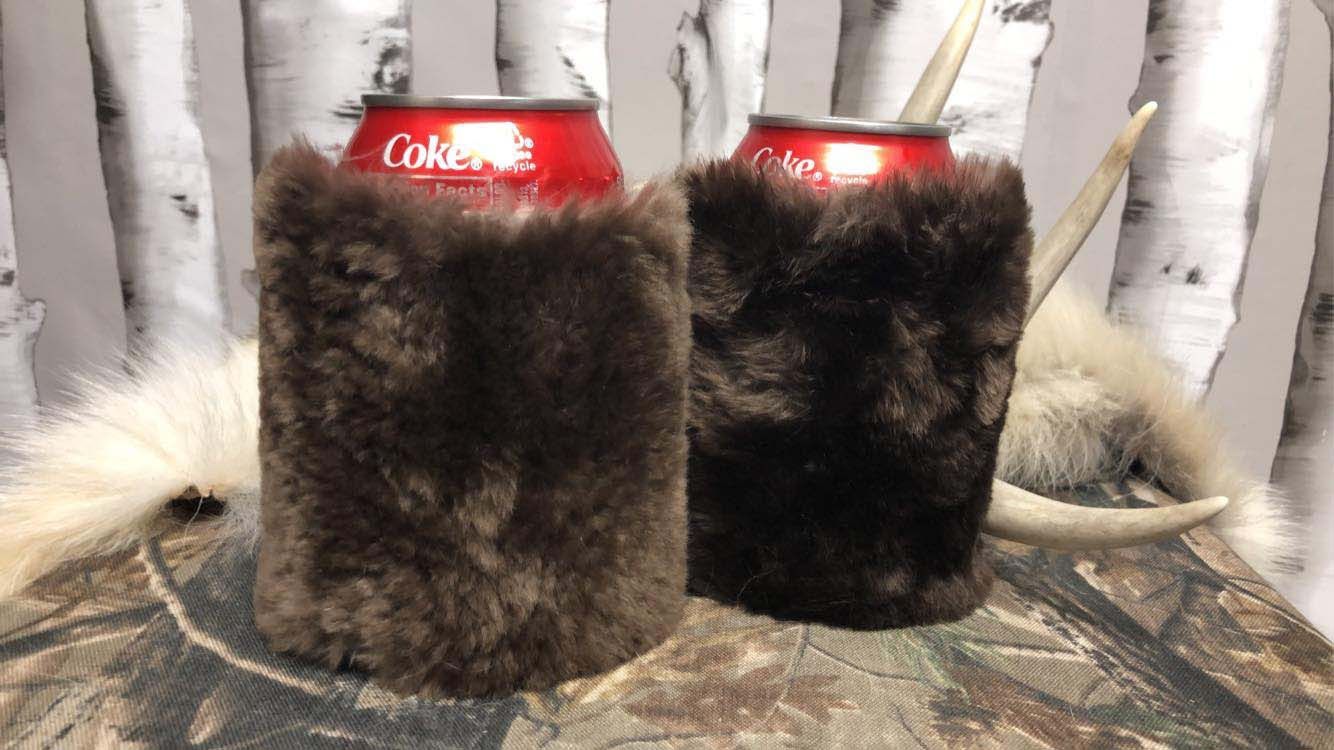 Two furry can holders are sitting next to each other on a table.