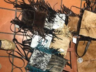 A bunch of handbags are sitting on top of each other on a tiled floor.