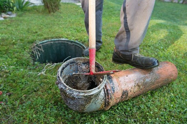 repair man repairing sewer backup