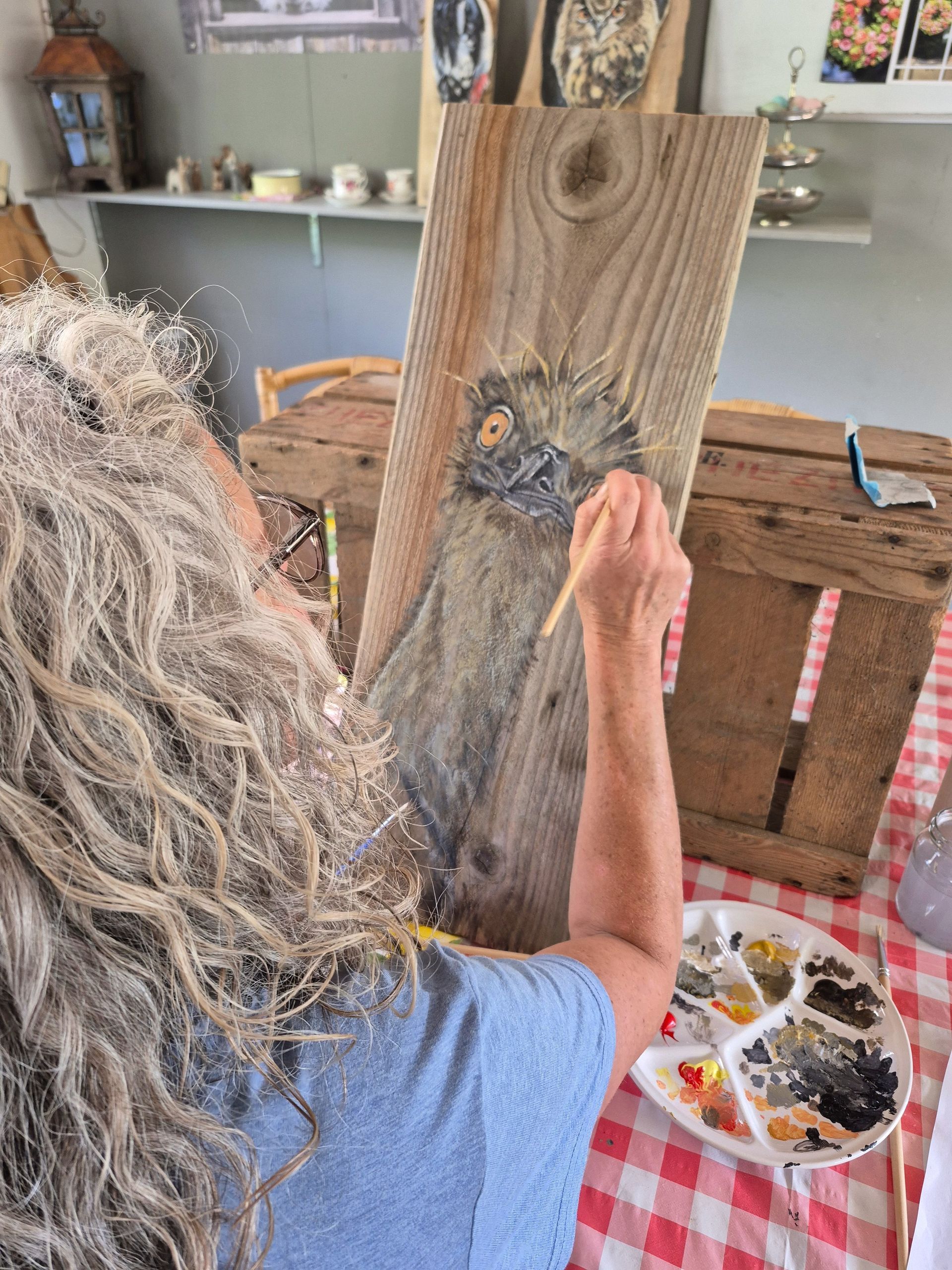 Deelnemer schildert een dier op Hoeksche Waards hout tijdens een creatieve schilderworkshop.