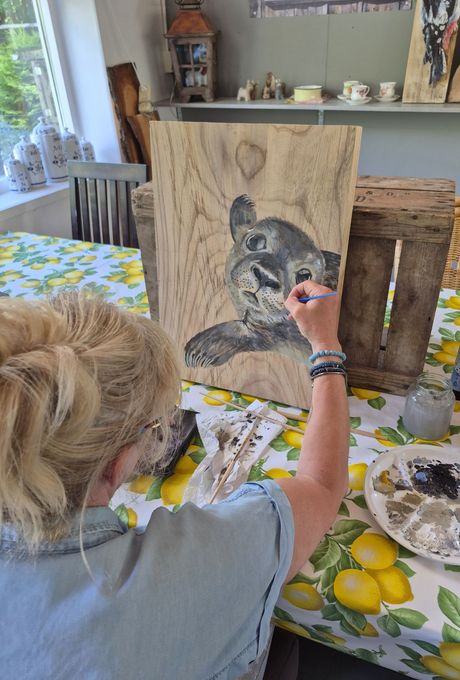 Deelnemer schildert een zelfgekozen dier op duurzaam Hoeksche Waards hout tijdens een creatieve workshop.